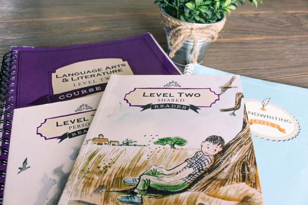 the good and the beautiful language arts and handwriting curriculum on wood table