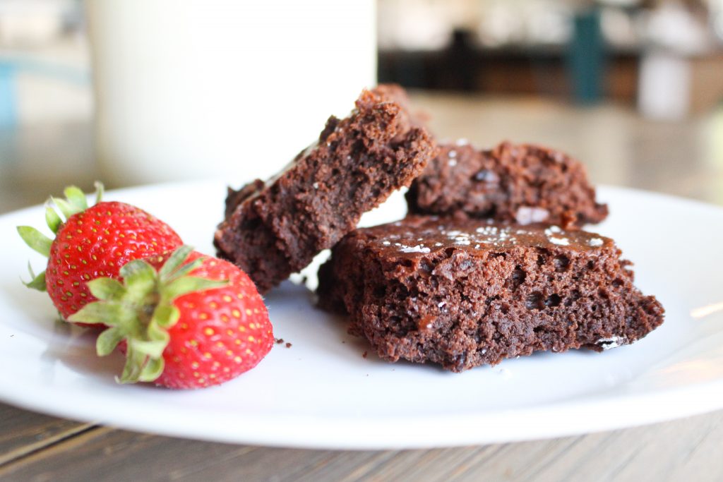 cut sourdough brownies on plate with strawberries