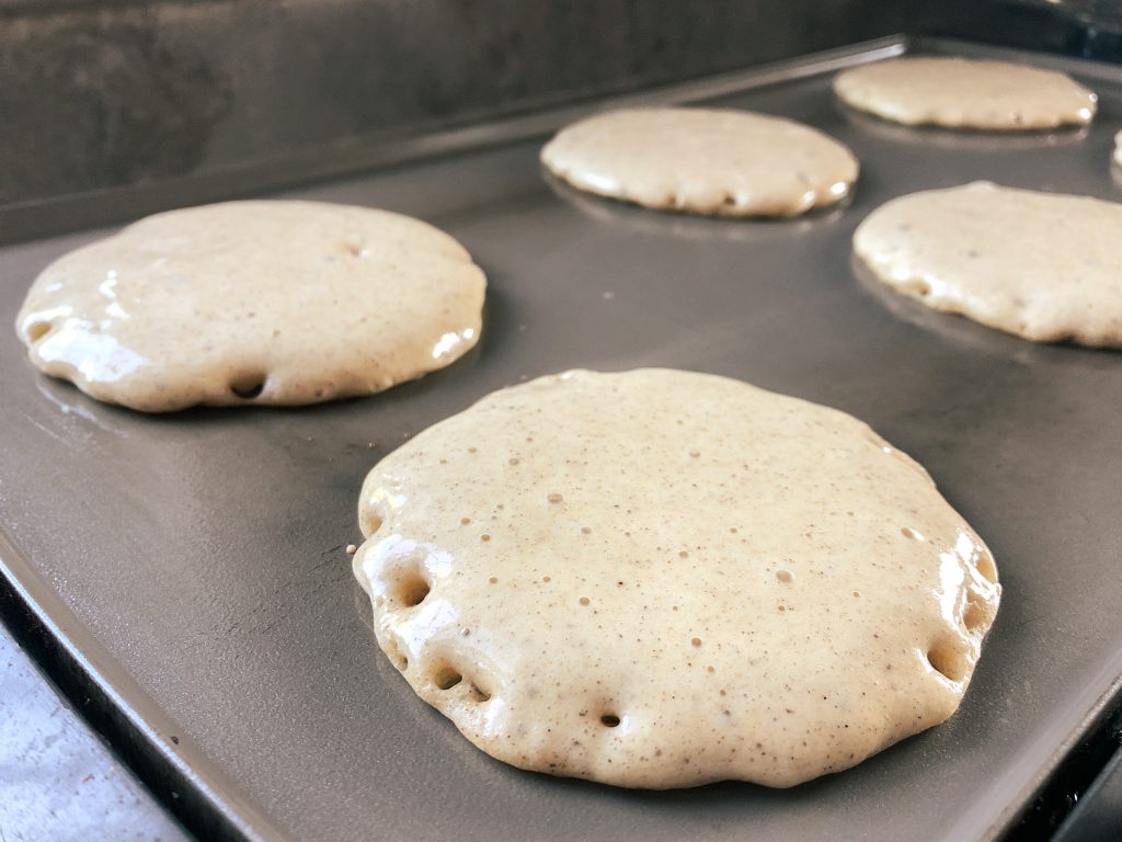 sourdough gingerbread pancakes cooking on griddle