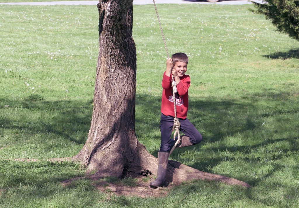 homeschooled boy playing outside on a homestead