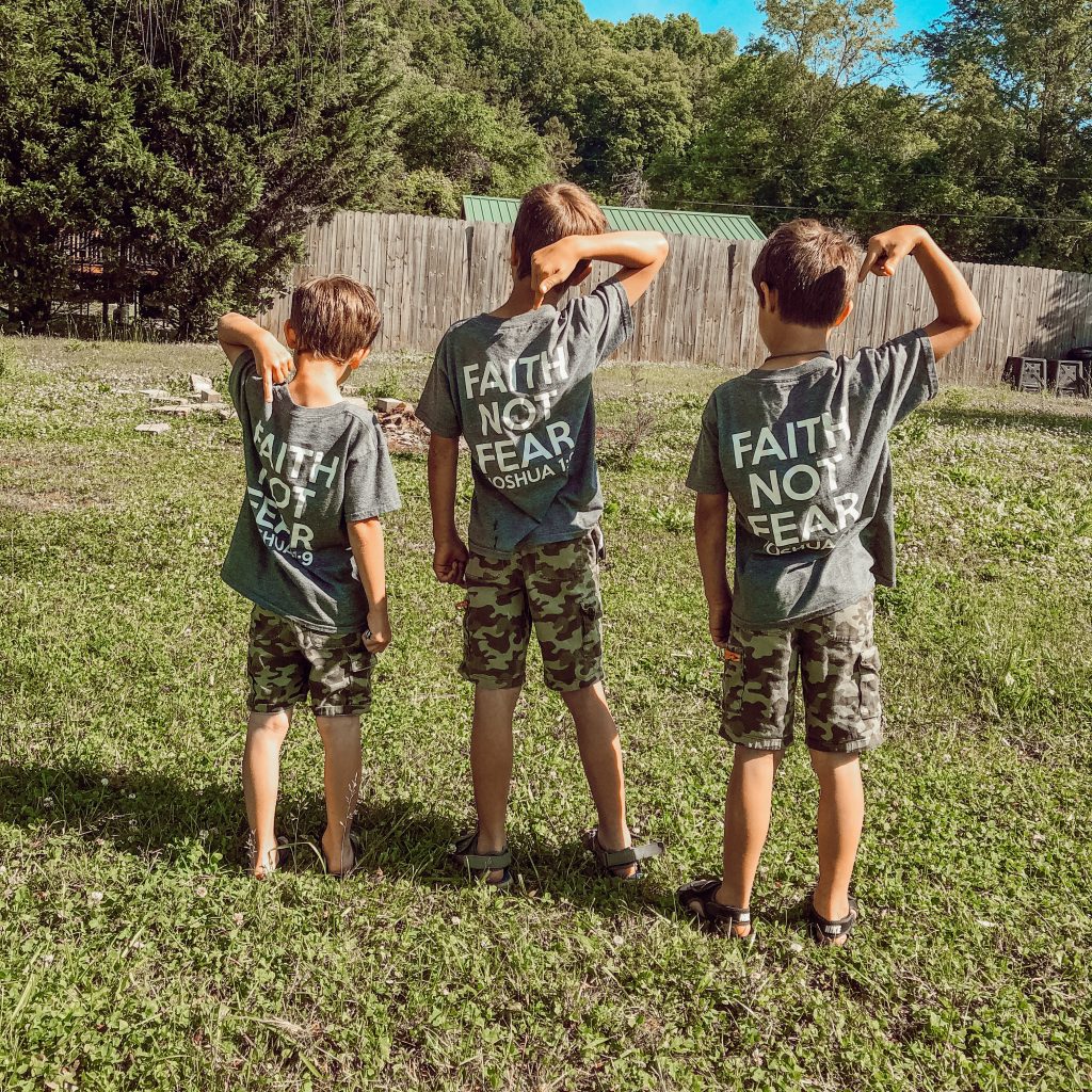 three young boys wearing t shirts that say faith not fear outside