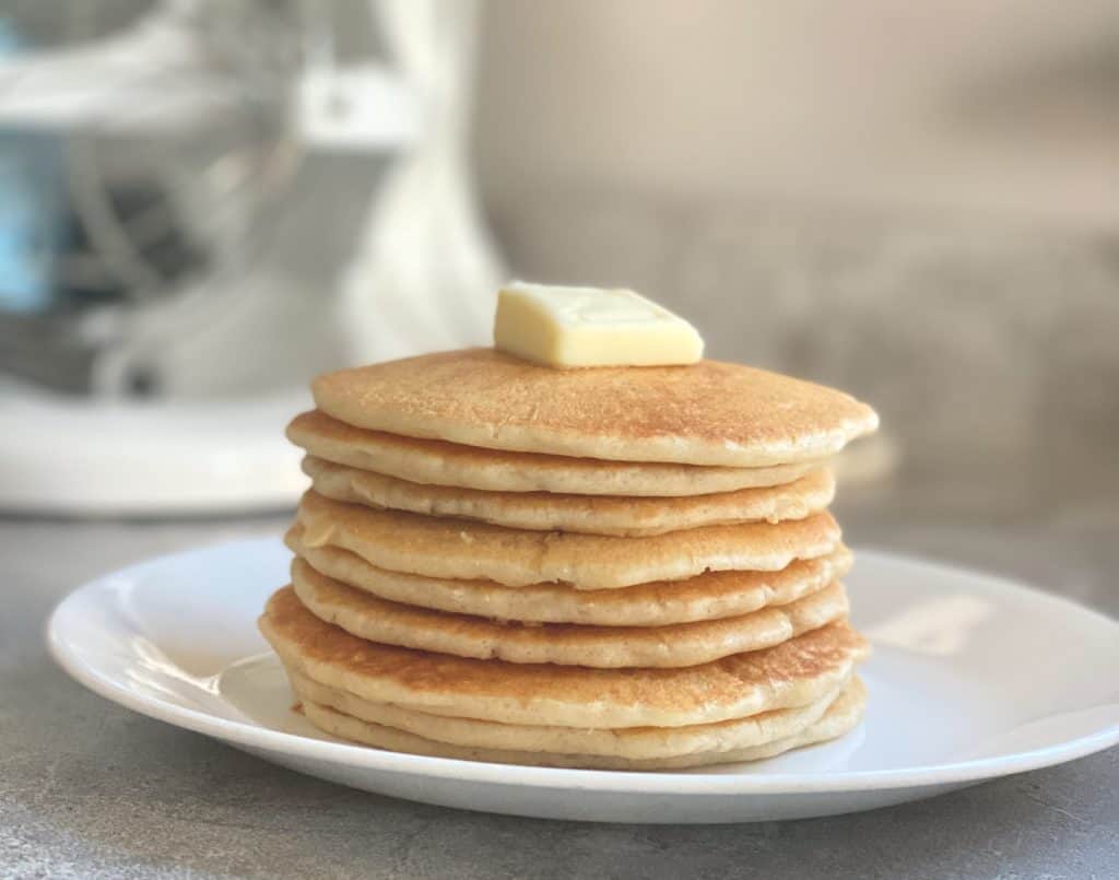 sourdough discard pancakes on plate topped with butter