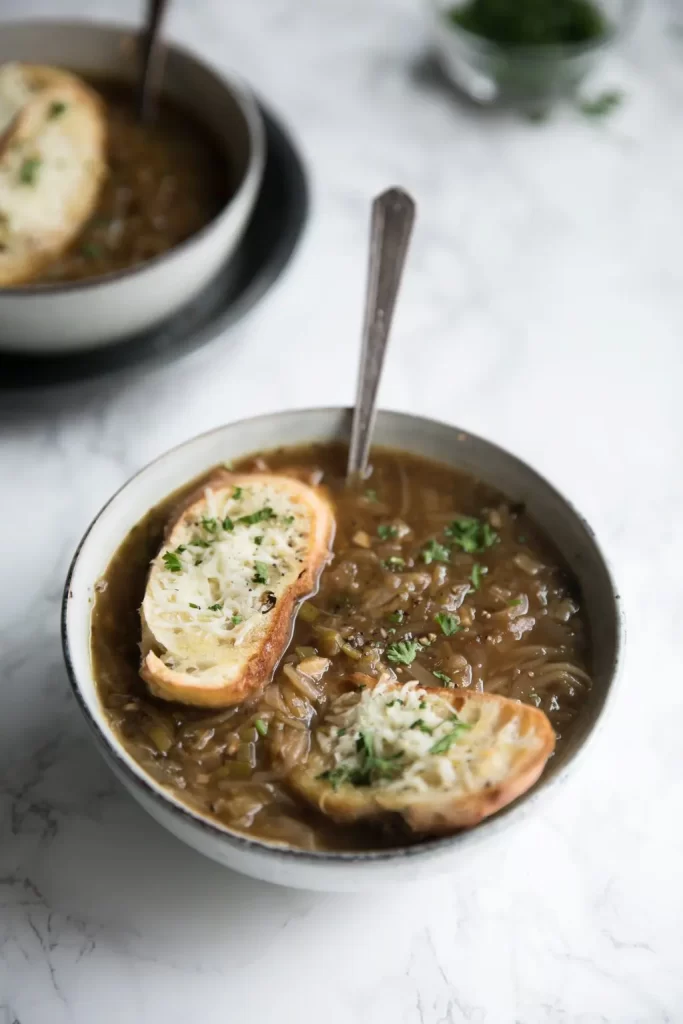six onion soup topped with crusty bread in white bowls