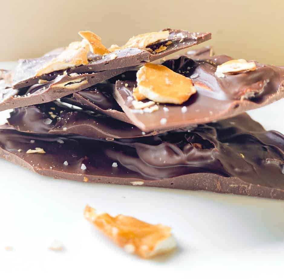 dark chocolate pretzel bark stacked on parchment paper