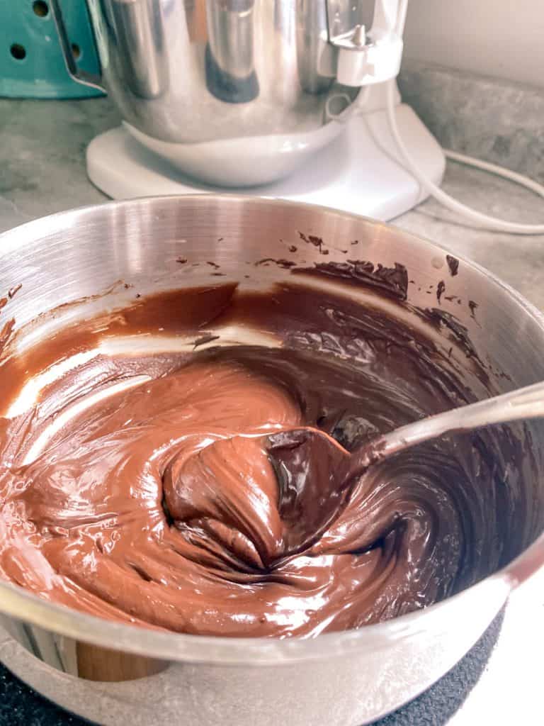 melted dark chocolate in saucepan with a spoon