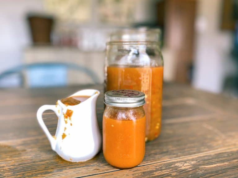 homemade fermented and unfermented hot sauces in jars and pitcher