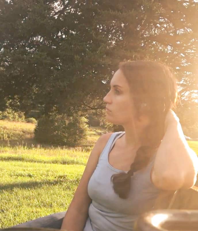 woman sitting on bench in sunset