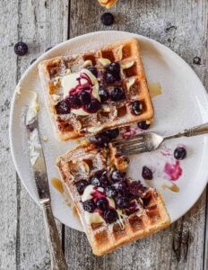 sourdough waffles topped with butter and blueberry compote